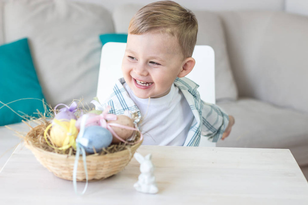 Милый мальчик играет с пасхальными яйцами и пасхальным кроликом. Праздники. Весна
. - Фото, изображение