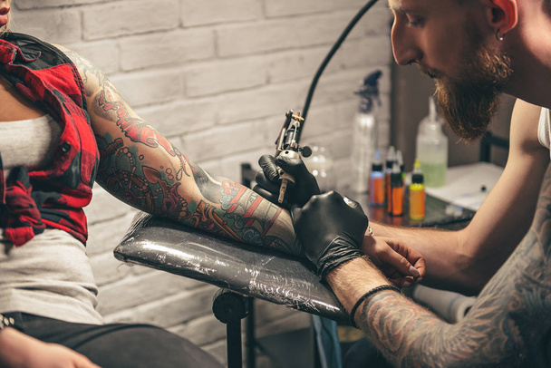 Calm man making tattoo on hand - Photo, image