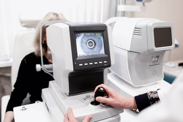 Optalmoloji kliniğinde göz testi makinesine bakan kadınlar - Fotoğraf, Görsel