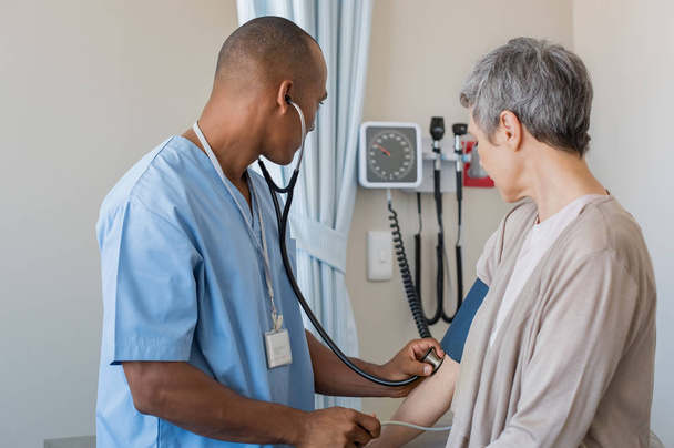 Nurse measuring blood pressure - Фото, изображение