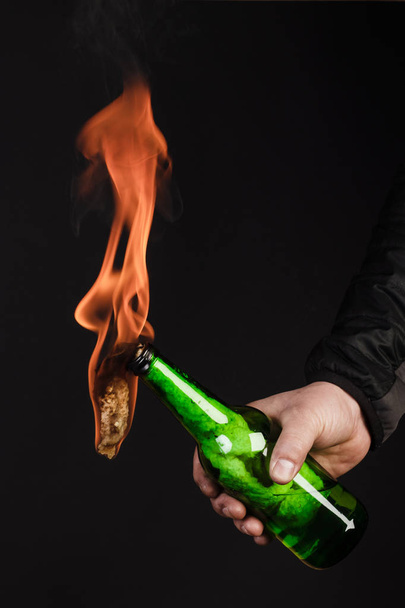 Glass bottle, the so-called Molotov cocktail in the hand of the  - Φωτογραφία, εικόνα