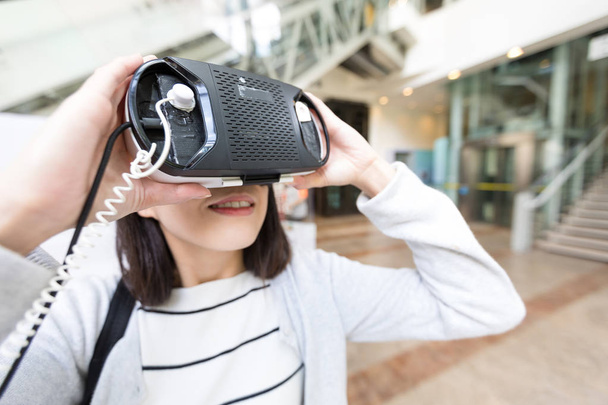 Жінка дивиться з пристроєм VR
 - Фото, зображення