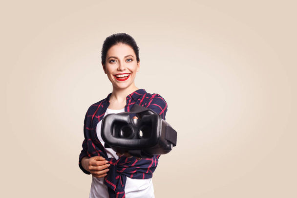 Young beautiful woman in casual style with virtual reality headset on beige background.  - Fotografie, Obrázek