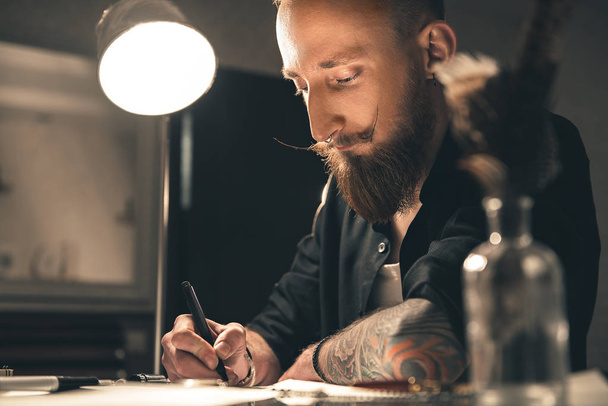 Considerate man making images at desk - 写真・画像