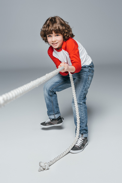 Cute boy play tug of war - Foto, Bild