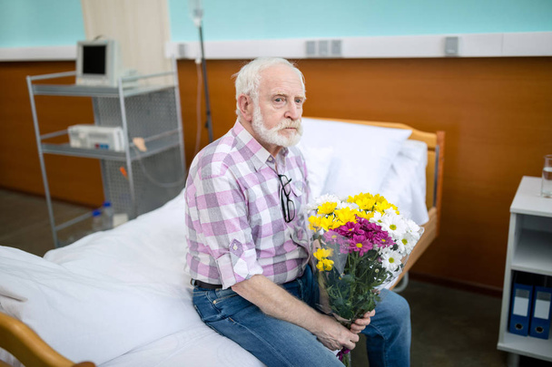 Senior man with flowers in hospital  - Foto, Bild