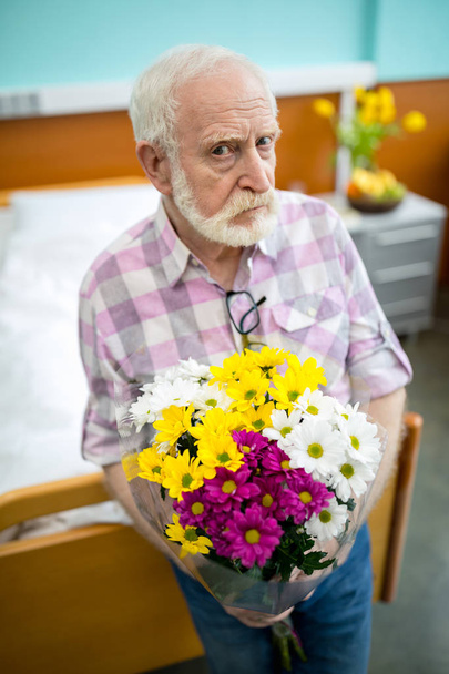 Hombre mayor con flores en el hospital
   - Foto, imagen
