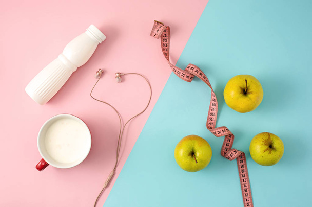 Vihreä omena ja pullo jogurttia mittanauhalla
 - Valokuva, kuva