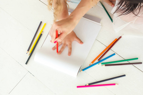 Little cute girl drawing a picture with colorful pencils laying  - Foto, Imagen