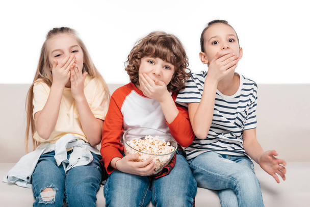 Cute children on couch with popcorn - Valokuva, kuva