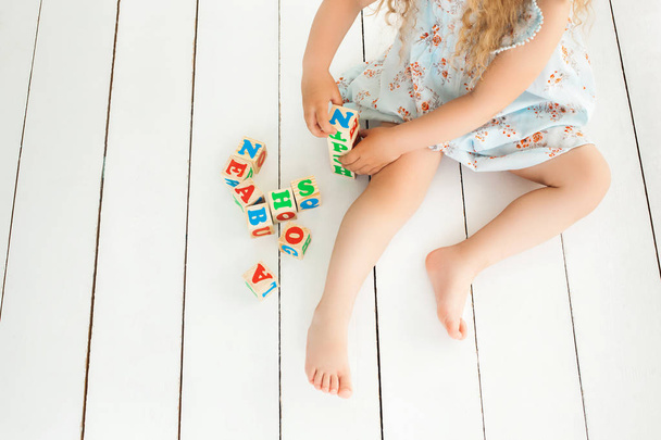 unkenntlich kleine süße Mädchen spielen mit abc Würfel und educa - Foto, Bild