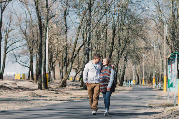 Happy couple in love hugging and sharing emotions, holding hands walking in the park - Foto, afbeelding