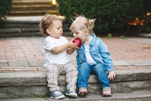 niños adorables compartiendo manzana
 - Foto, Imagen