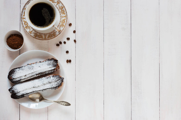 Chocolate eclairs and coffee beans on a wooden background - Foto, afbeelding