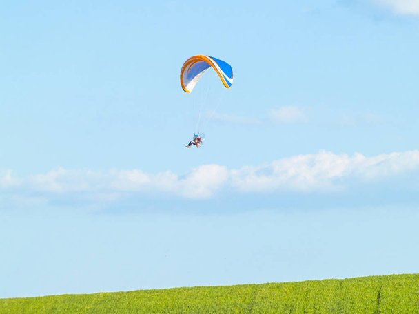 Een man die het beoefenen van extreme sporten met paraglider met motor - Foto, afbeelding