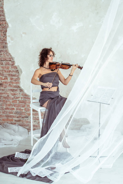 美しい女性がバイオリンを弾き - 写真・画像