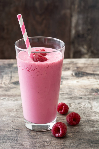 Raspberry smoothie in glass on wooden table - Photo, Image