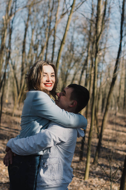 Ευτυχισμένο ζευγάρι στην αγάπη αγκάλιασμα και ανταλλαγή συναισθημάτων, κρατώντας τα χέρια, τα πόδια στο πάρκο - Φωτογραφία, εικόνα