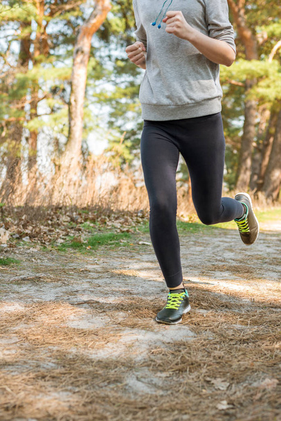 Ein Mädchen in Strumpfhosen und Kapuzenpullover läuft von Natur aus. Sportleben - Foto, Bild