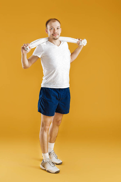young athlete holding towel on yellow background - Fotografie, Obrázek