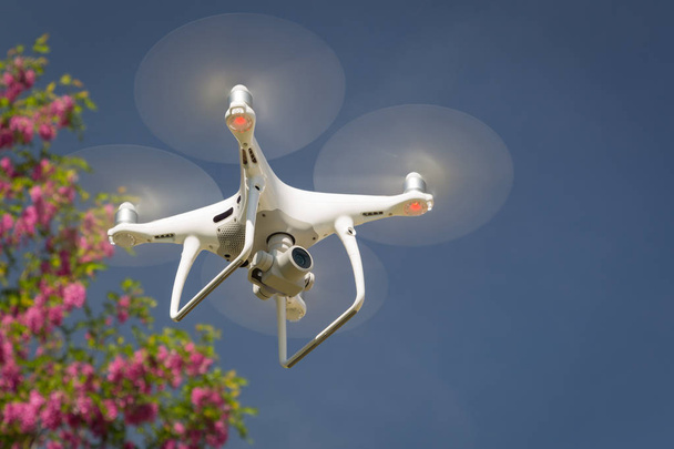 Unmanned Aircraft System (UAV) Quadcopter Drone In The Air. - Photo, Image