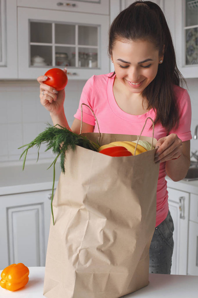 Mujer bastante joven con enorme bolsa de frutas y verduras frescas
.  - Foto, imagen