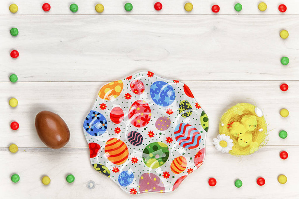 Œuf de chocolat de Pâques avec explosion colorée de bonbons et de bonbons sur fond de bois gris coloré
. - Photo, image