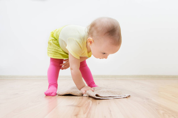 Cute little child girl makes cleaning the house. Girl wipes the floor. - Foto, Bild