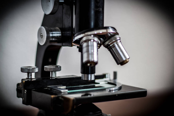 Un joven médico estudia al microscopio, sosteniendo cuidadosamente una copia
 - Foto, Imagen