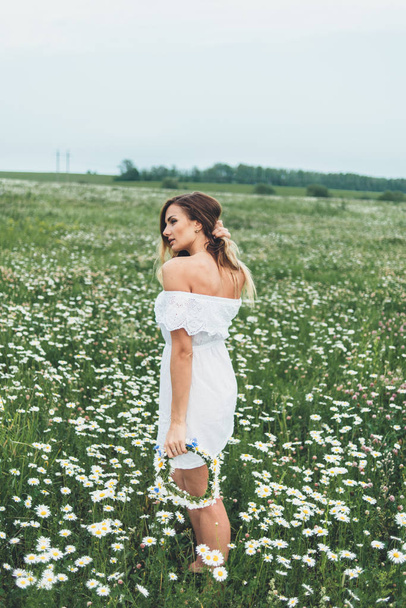  A girl in a field of chamomiles - Foto, afbeelding
