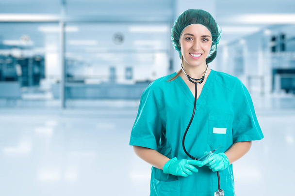 Молода медсестра зі стетоскопом стоїть і виглядає шприцом в руці. Концепція медичної та
. - Фото, зображення