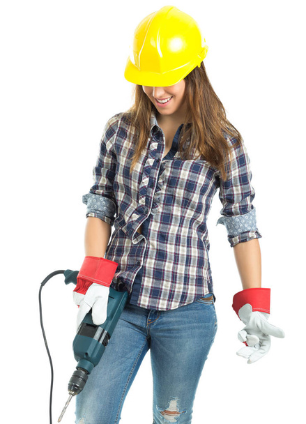 Aantrekkelijke jonge vrouw bouwer met boor gereedschap blij voor goed werk. Geïsoleerd op witte achtergrond. - Foto, afbeelding