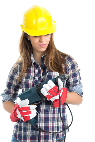 Приваблива молода жінка-будівельник з інструментом для свердління щаслива за хорошу роботу. Ізольовані на білому тлі
. - Фото, зображення