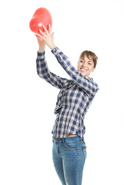 Beautiful young brunette woman playing with red heart shape balloon - Photo, Image