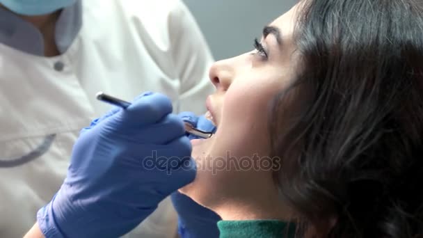 Dentist in gloves examining patient. - Кадри, відео
