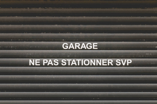 Garážové dveře s zmínka ve francouzštině "Do garáže není parkování" - Fotografie, Obrázek