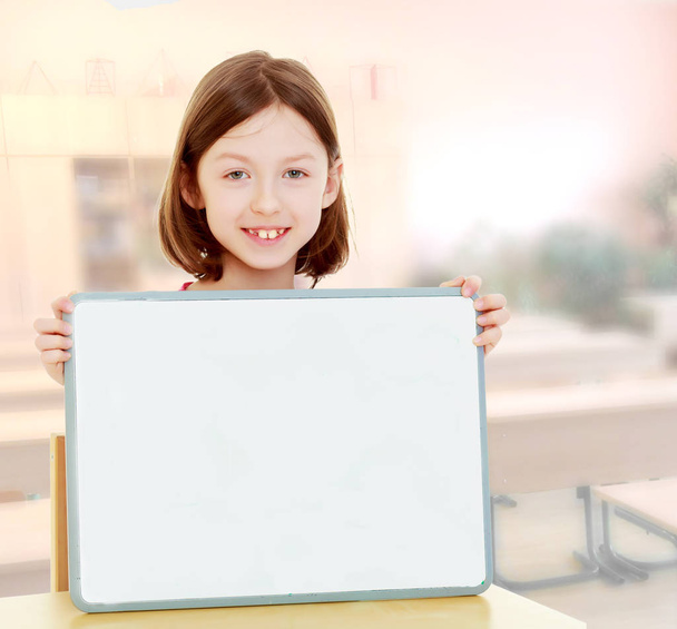 Little girl holding white poster. - Фото, зображення