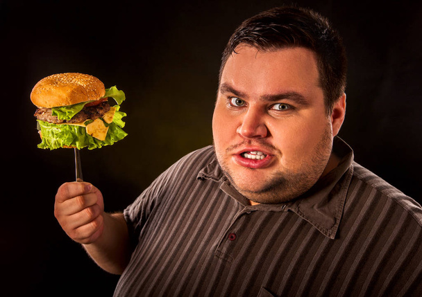 Fat man eating fast food hamberger. Breakfast for overweight person. - Photo, Image