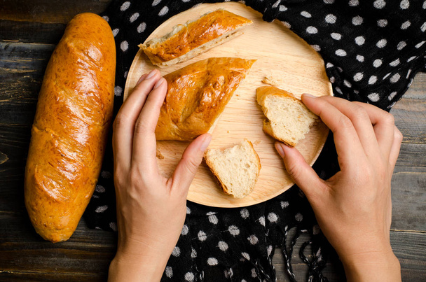 Φρέσκο ψωμί στο ξύλινο πιάτο έτοιμο να τρώει - Φωτογραφία, εικόνα