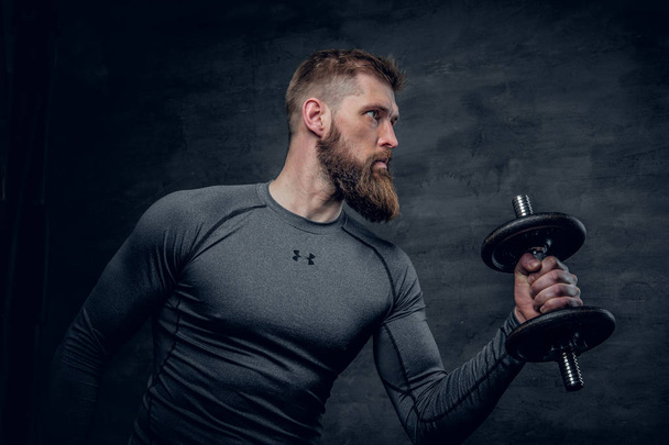 Sporty bearded man holds dumbbell - Photo, Image