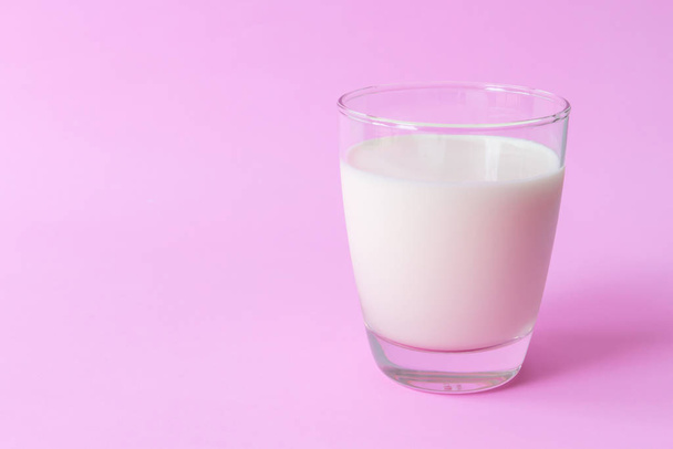ピンクの背景、食べ物と健康的な概念、選択とソフト フォーカスの飲み物にミルクのガラスをクローズ アップ - 写真・画像