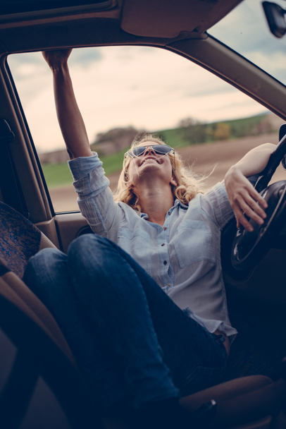 Vrouwelijke bestuurder zitten in uit wegvoertuig op road trip - Foto, afbeelding