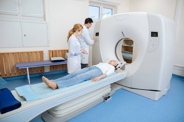Nice professional doctors using a CT scanner - Foto, afbeelding