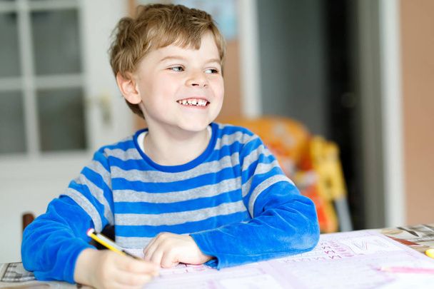Happy school kid boy at home making homework - Photo, Image