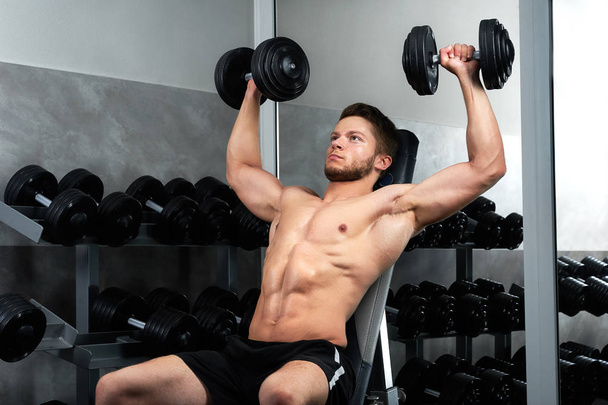 Handsome young athlete working out at the gym - Foto, imagen