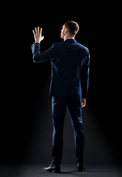 businessman in suit touching something invisible - Photo, Image