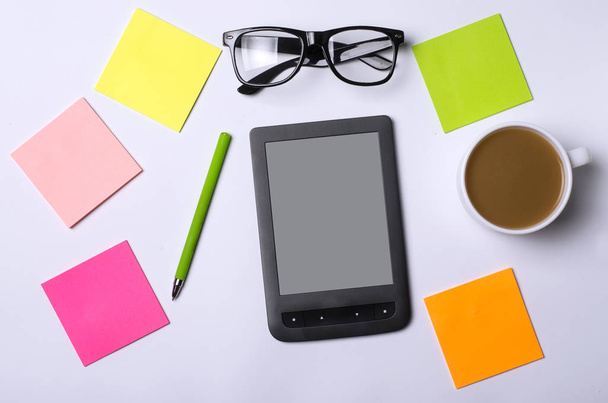 Office table with accessories: a tablet, glasses, pen, paper. - Foto, immagini
