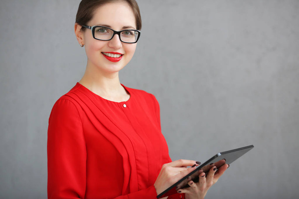 Fashion business woman with a red shirt and glasses portrait, holding a tablet in his hands - Foto, imagen