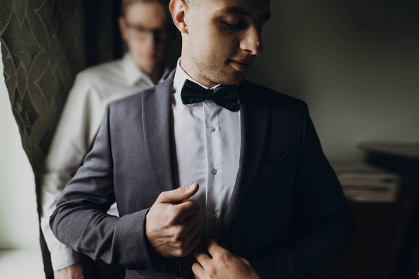 groomsmen helping groom getting ready - Fotografie, Obrázek