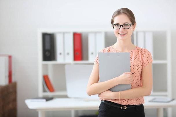Business woman holding a writing tablet in the office - Foto, immagini